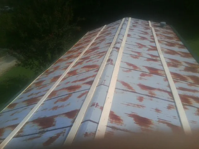 Rusted metal roof panels with new wood purlins before replacement — Storm Damage Roof Repair in Stennis Space Center by Roofing Brothers