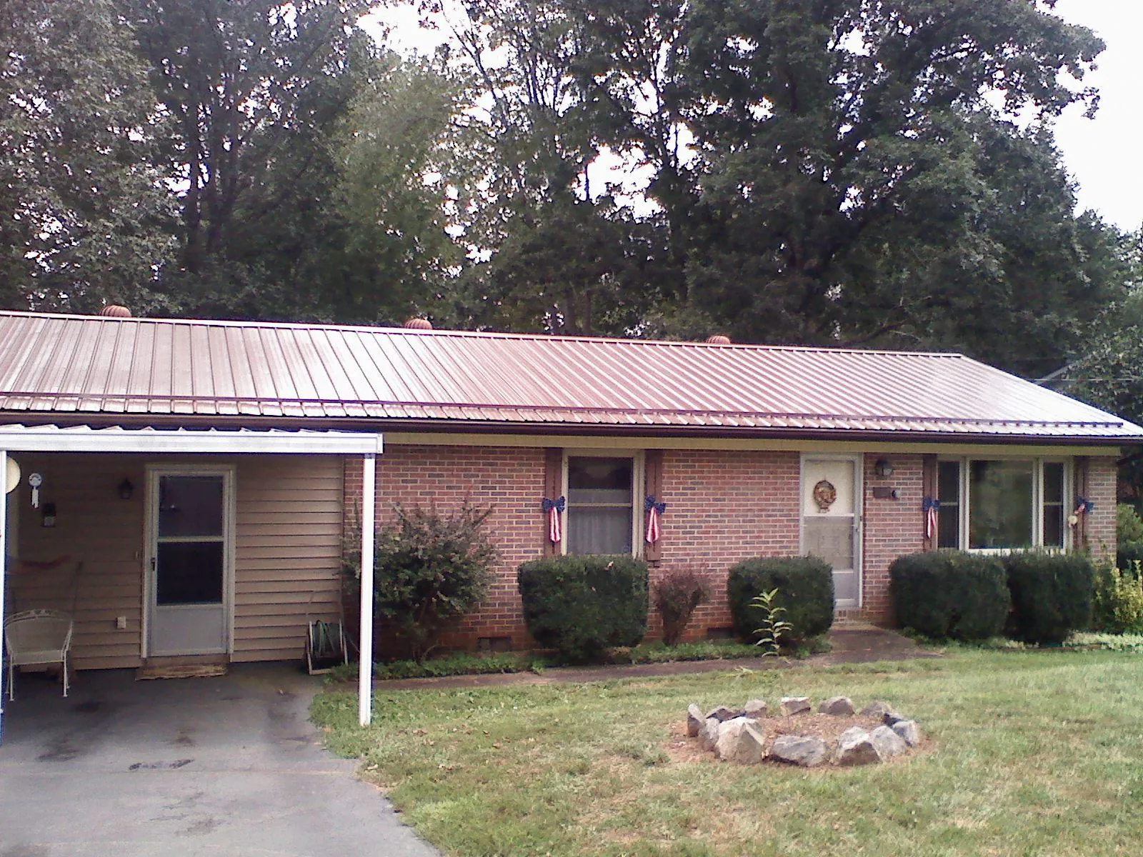 Bronze metal roof and carport on a brick ranch home — Roof Repair work by our crew in Stennis Space Center