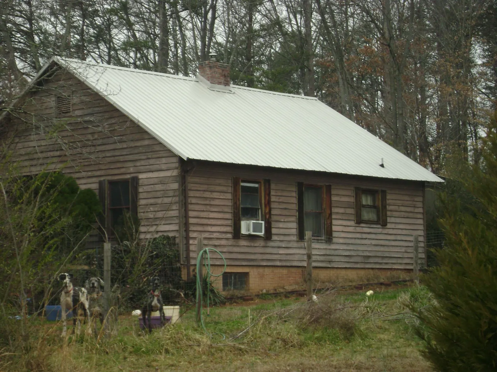 White metal roof on an old wood sided farmhouse, from a Asphalt Shingle Roof Repair job in Stennis Space Center